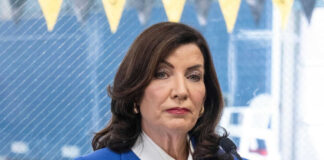 Woman in blue blazer speaking into microphone