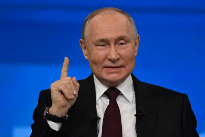 Man in suit gestures with raised index finger