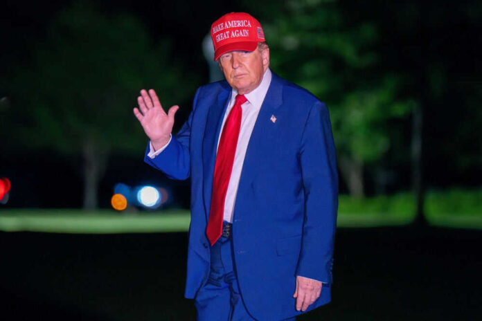 Man in suit wearing red hat outside at night