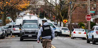 Law enforcement officer walking towards a crime scene marked by police tape