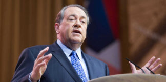 Man in suit speaking at podium on stage
