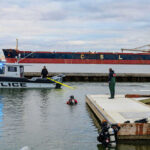 Police boat near dock with divers in water