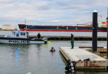 Police boat near dock with divers in water