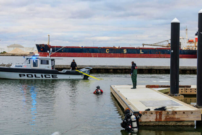 1900015951 Police boat near dock with divers in water