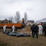 People in protective gear with a blue truck