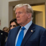 Man in blue suit with serious expression indoors