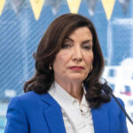 Woman in blue blazer speaking into microphone