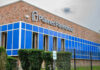 Brick building with blue windows and logo signage