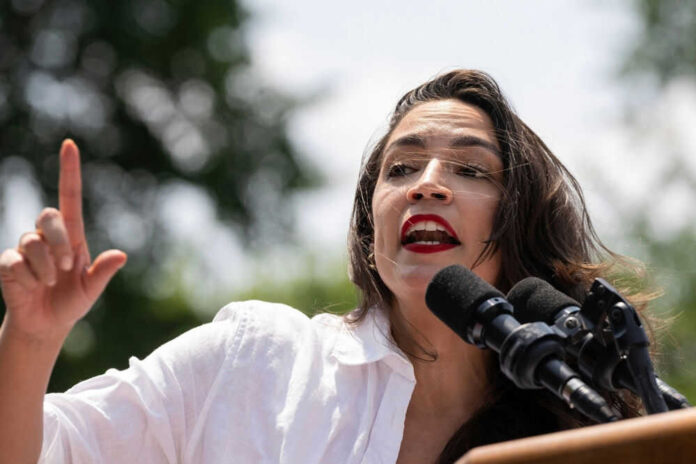 Person speaking passionately at outdoor event with microphones