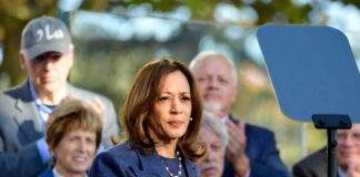 Woman speaking at podium with audience behind her