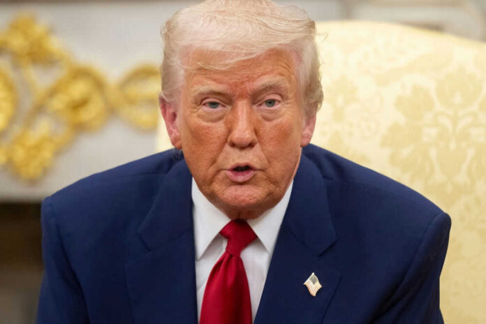 Man in suit with red tie speaking indoors