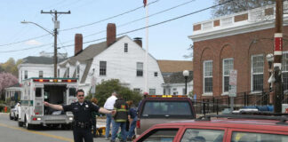 Police officer directing traffic near ambulance scene