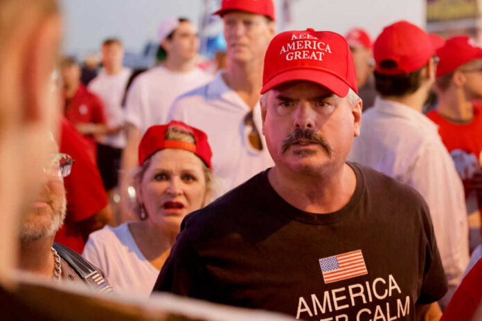 Man wearing red hat in crowded outdoor gathering