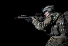 Germany’s Secret War Plan EXPOSED Soldier aiming rifle in tactical gear against black background