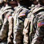Military personnel in camouflage uniforms standing in line