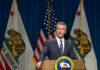 Newsom’s Ex-Chief ARRESTED – Massive Fraud Uncovered Man speaking at podium with California and US flags