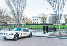 Afghan Ex-CIA Shooter Sparks White House Chaos Police car and officers in front of large building