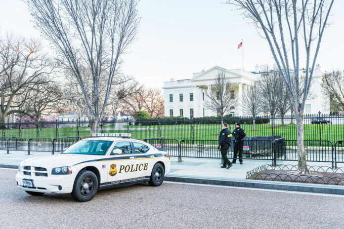 612294485 Police car and officers in front of large building