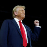 Man in suit with raised fist in air
