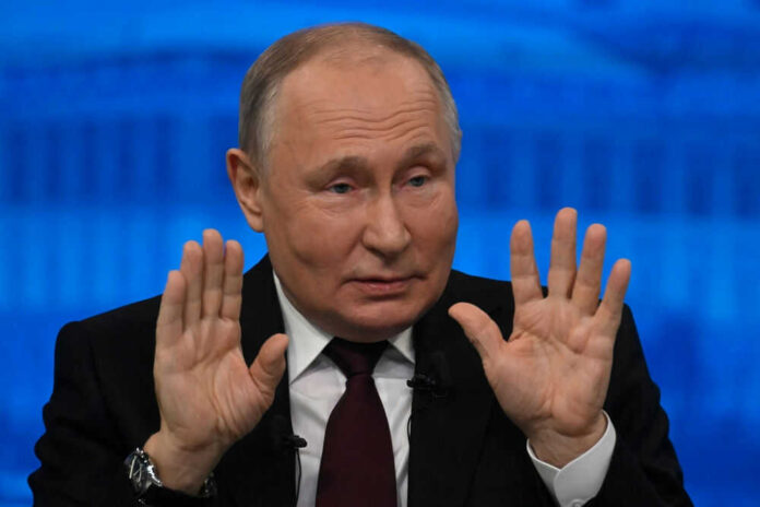 Man in suit raising both hands speaking