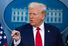 Man in suit speaking at a press briefing